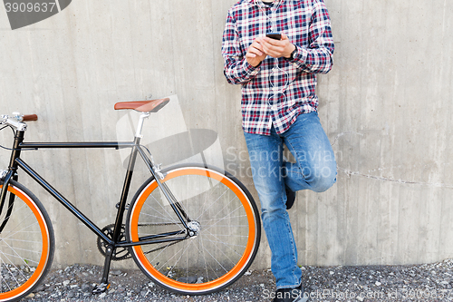 Image of close up of hipster man with smartphone and bike