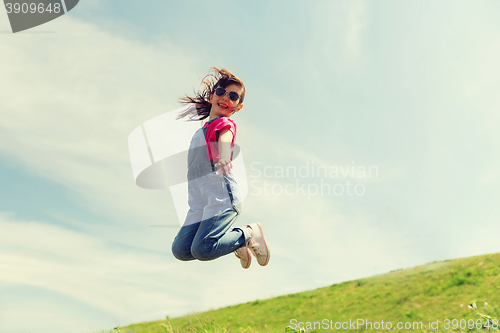 Image of happy little girl jumping high outdoors