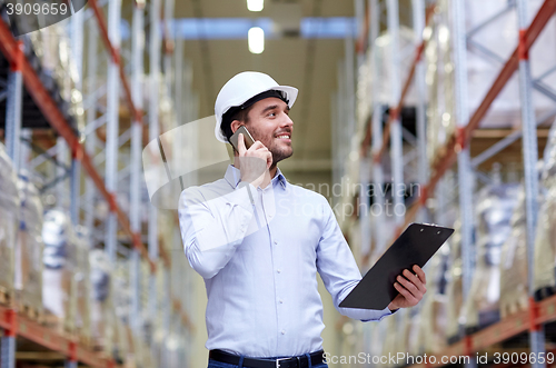 Image of man with clipboard and smartphone at warehouse