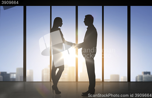 Image of business partners silhouettes shaking hands