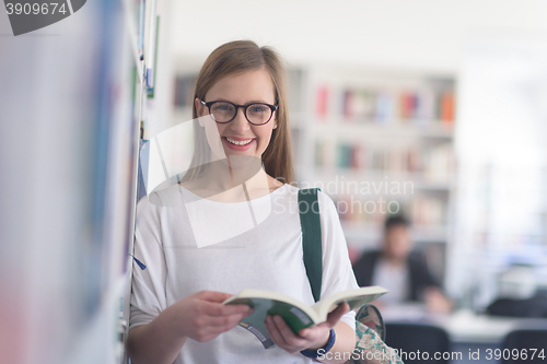 Image of portrait of famale student reading book in library