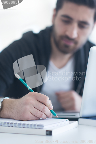 Image of student in school library using laptop for research