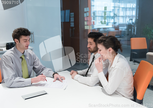 Image of young couple signing contract documents on partners back