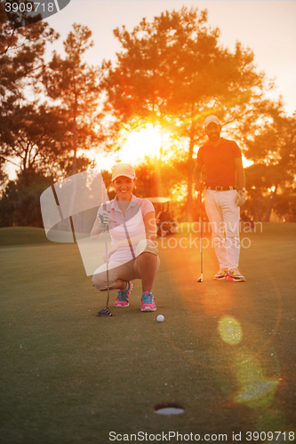 Image of couple on golf course at sunset