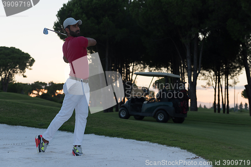 Image of golfer hitting a sand bunker shot on sunset