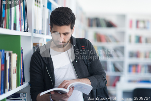 Image of portrait of student while reading book  in school library