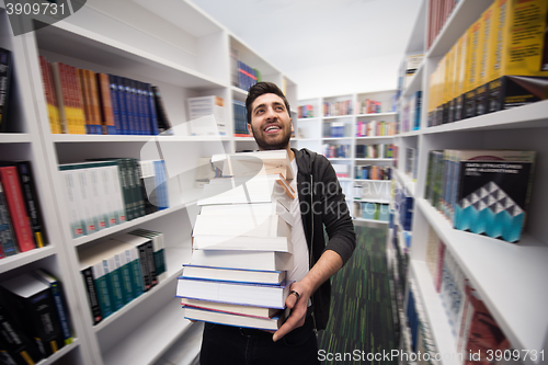 Image of Student holding lot of books in school library