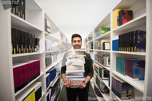 Image of Student holding lot of books in school library