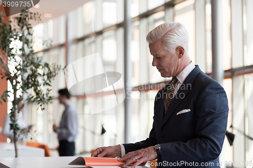 Image of senior business man reading magazine