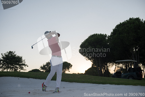 Image of golfer hitting a sand bunker shot on sunset