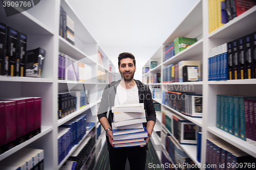 Image of Student holding lot of books in school library