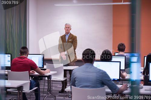 Image of teacher and students in computer lab classroom