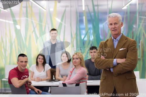 Image of portrait of  teacher with students group in background