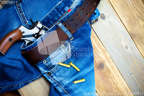 Image of fashion old blue jeans and vintage revolver