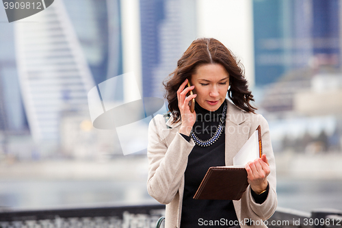 Image of beautiful middle-aged woman using a smartphone