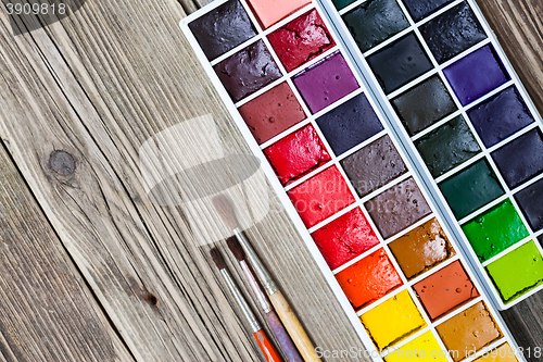 Image of handmade aquarelle paint-box and three brushe