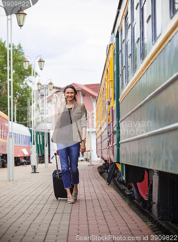 Image of beautiful middle-aged woman with a luggage