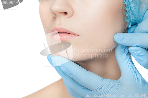 Image of Plastic surgery concept. Doctor hands in gloves touching woman face