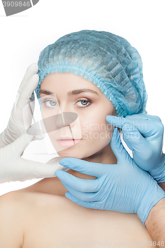 Image of Plastic surgery concept. Doctor hands in gloves touching woman face