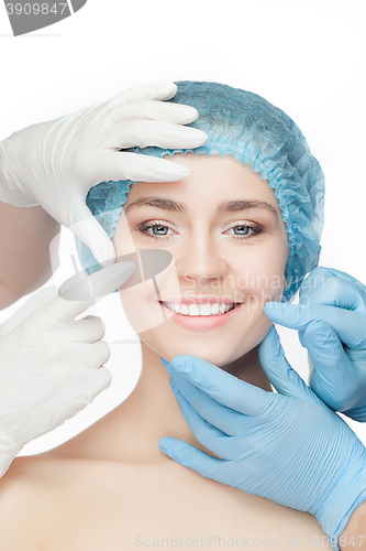 Image of Plastic surgery concept. Doctor hands in gloves touching woman face