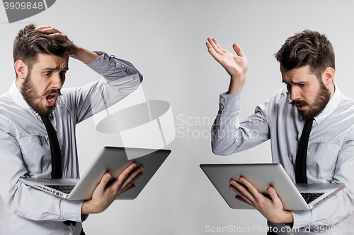 Image of The young confused and frustrated man with his laptop computer