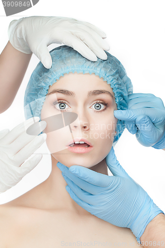 Image of Plastic surgery concept. Doctor hands in gloves touching woman face