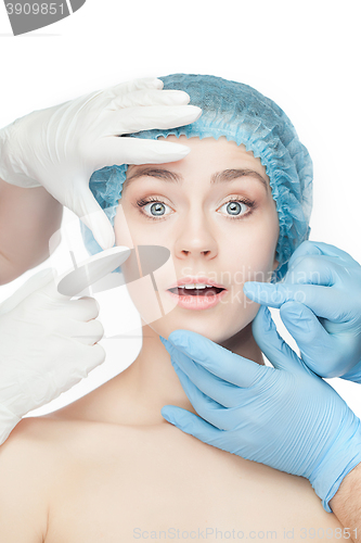 Image of Plastic surgery concept. Doctor hands in gloves touching woman face