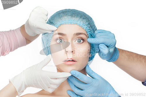 Image of Plastic surgery concept. Doctor hands in gloves touching woman face