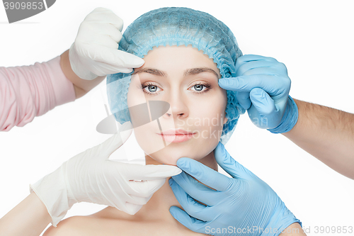 Image of Plastic surgery concept. Doctor hands in gloves touching woman face