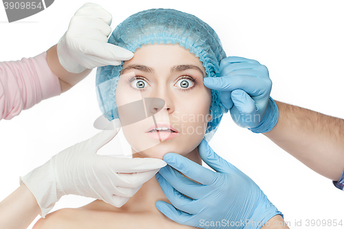 Image of Plastic surgery concept. Doctor hands in gloves touching woman face
