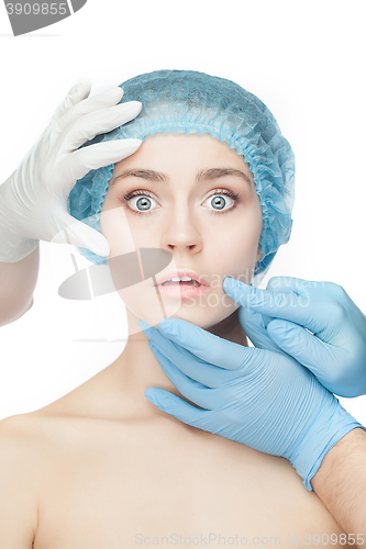 Image of Plastic surgery concept. Doctor hands in gloves touching woman face