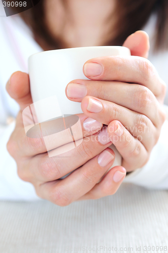 Image of Hands holding a cup