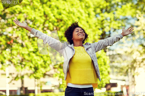 Image of happy african american young woman in summer park