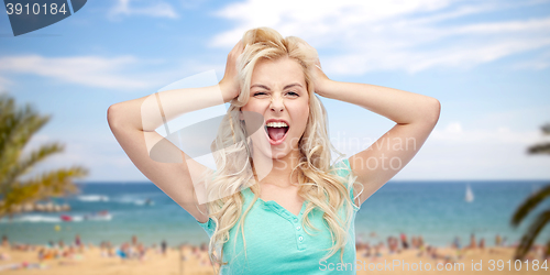 Image of smiling young woman holding to her head or hair