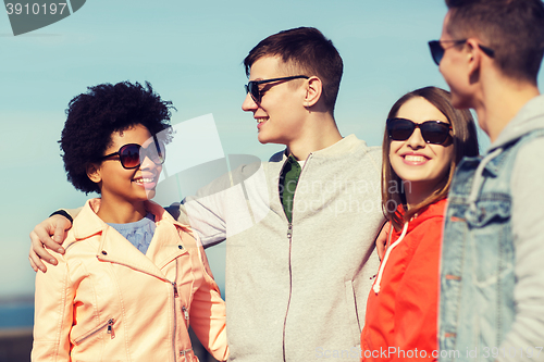 Image of happy teenage friends in shades talking on street