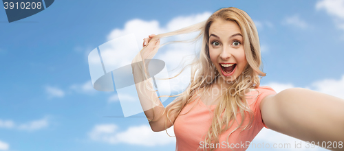 Image of smiling young woman taking selfie