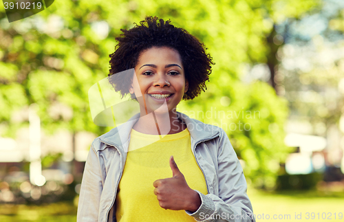 Image of happy african american young woman in summer park