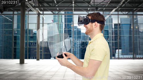 Image of happy man in virtual reality headset with gamepad