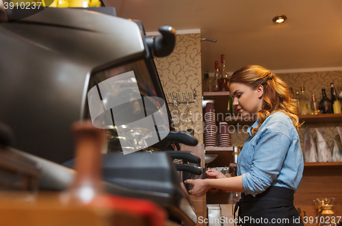 Image of barista woman making coffee by machine at cafe