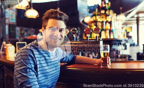 Image of happy man drinking beer at bar or pub