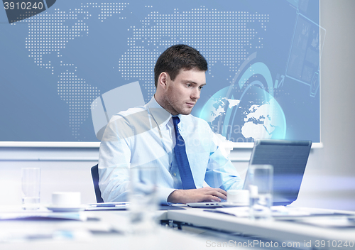 Image of businessman with laptop working in office