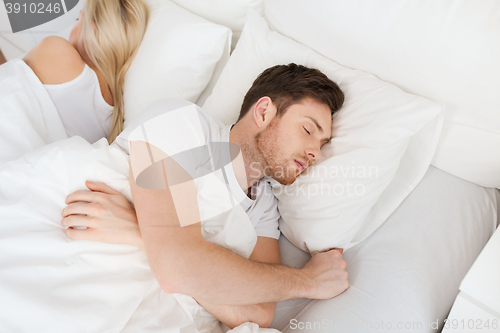 Image of couple sleeping in bed at home