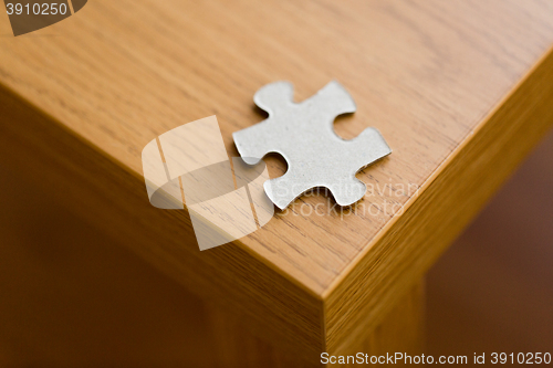 Image of close up of puzzle piece on wooden surface