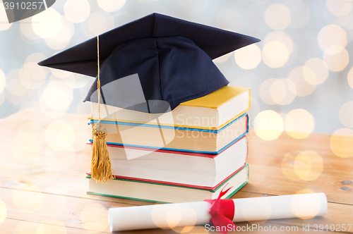 Image of close up of books with diploma and mortarboard