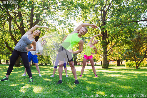 Image of group of friends or sportsmen exercising outdoors