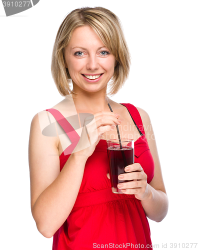 Image of Young woman is drinking cherry juice