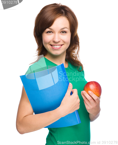 Image of Young student girl is holding book and apple
