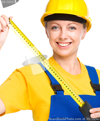 Image of Young construction worker with tape measure