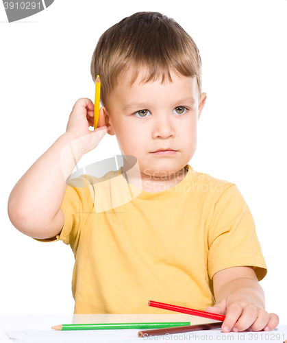 Image of Little boy is holding color pencils