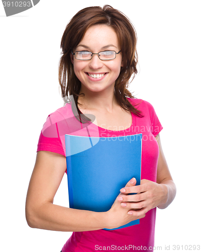 Image of Young skinny student girl is holding exercise book